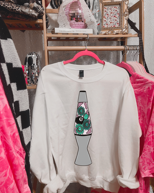 White sweatshirt with a colorful lava lamp design on a hanger against a background of clothing.